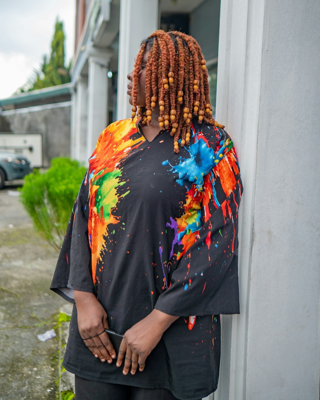 Home woman-with-colorful-paint-splatter-shirt-and-beaded-hair-pb5kxht-7ma